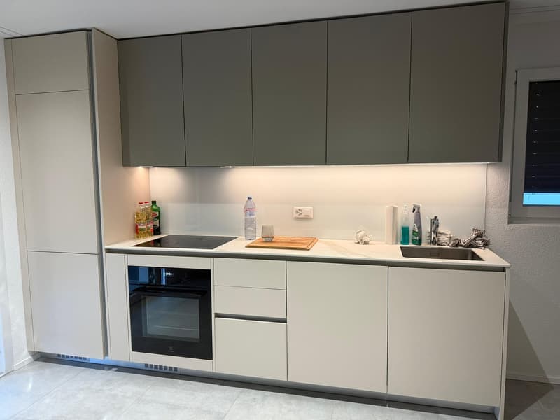 modern kitchen with white cabinets, black stove, oven, sink, countertop, built-in lighting