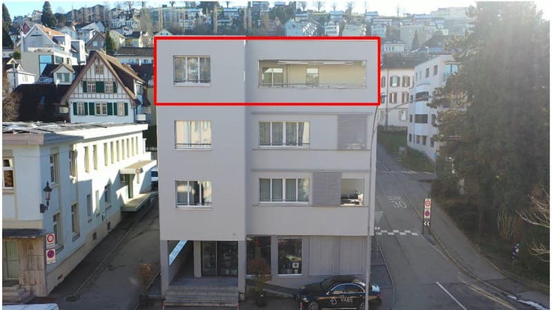 4 story building, white exterior, multiple windows, balcony on the second floor, ground floor with shop windows