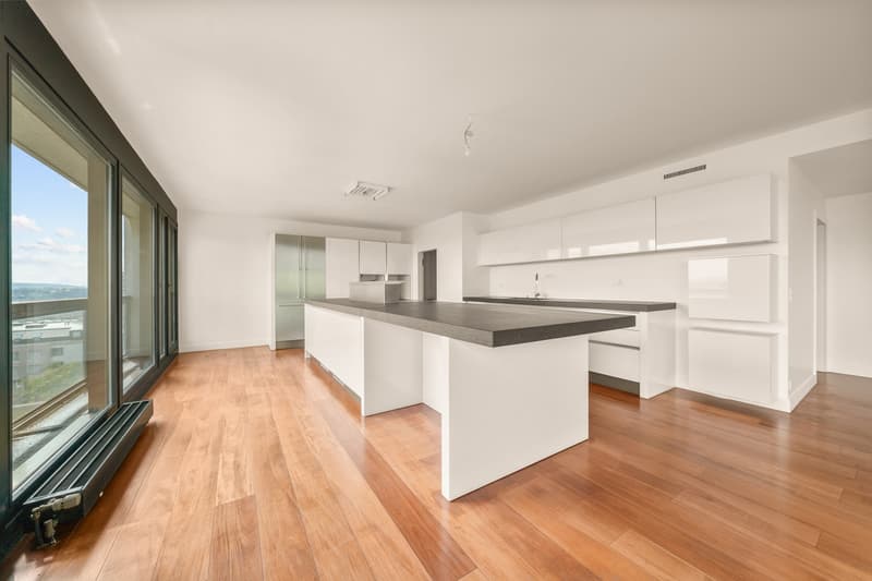 Central island kitchen with marble countertop, white cabinets, hardwood floors, large windows