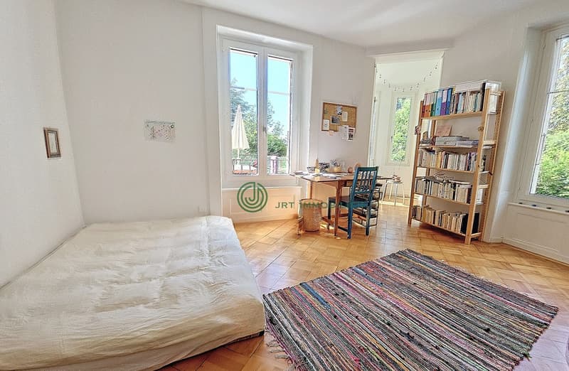 wooden floor, white bed, desk, bookshelf, two chairs, view of outside