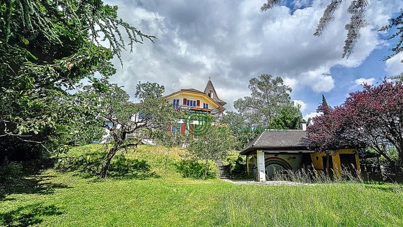 House on a hill, surrounded by trees, spacious lawn, small wooden house, steep stairs, white exterior, red trims