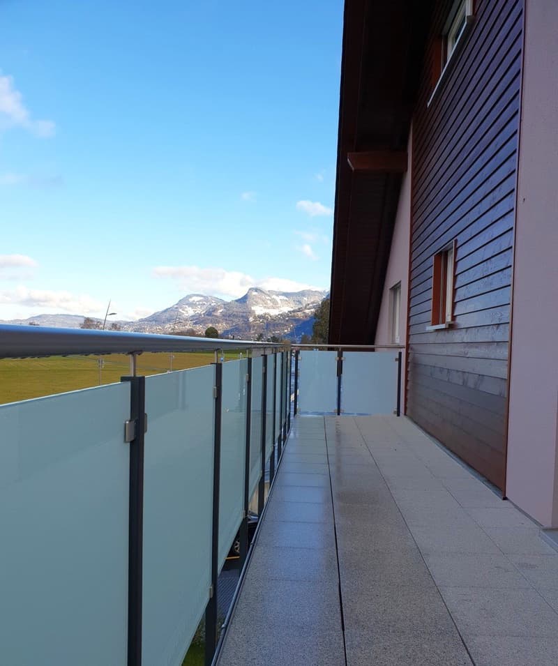 Balcony with glass railings, tiled floor, view of mountains