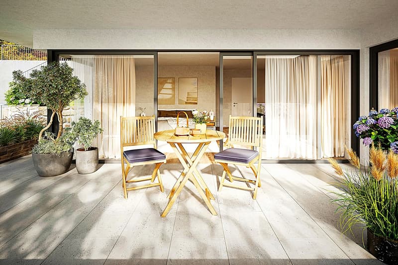 Outdoor patio with wooden table and chairs, potted plants, sliding glass doors, and a view of a bedroom