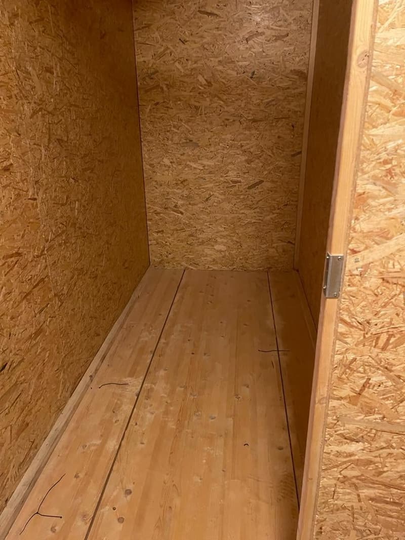 empty room with wooden floor and particleboard walls