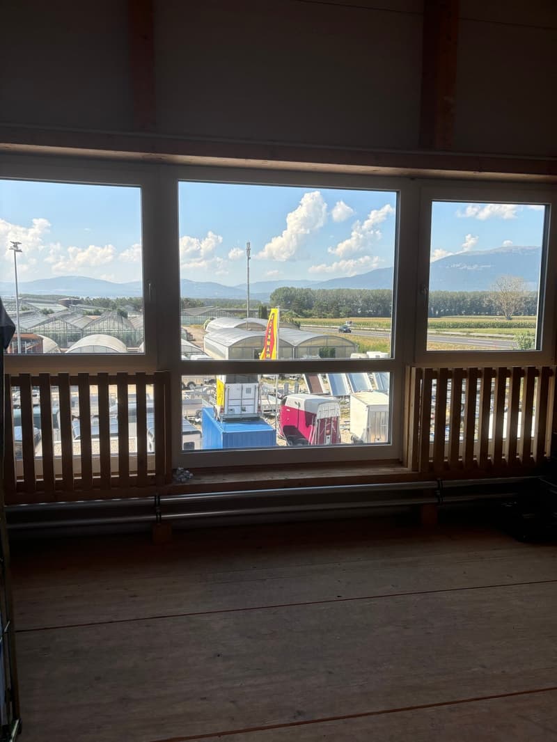 large window, wooden floor, view of mountains and sky