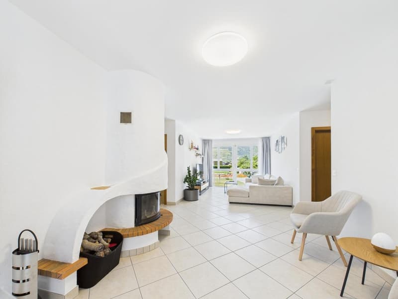 white walls, tiled floor, fireplace, couch, armchair, plant, table, lamp