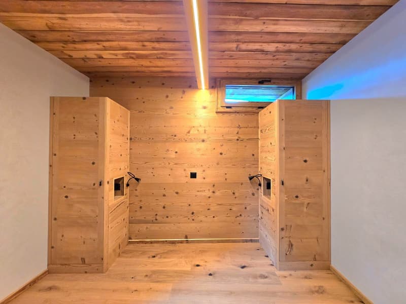 wooden walls, wooden floor, two wooden cabinets, small window, two lamps