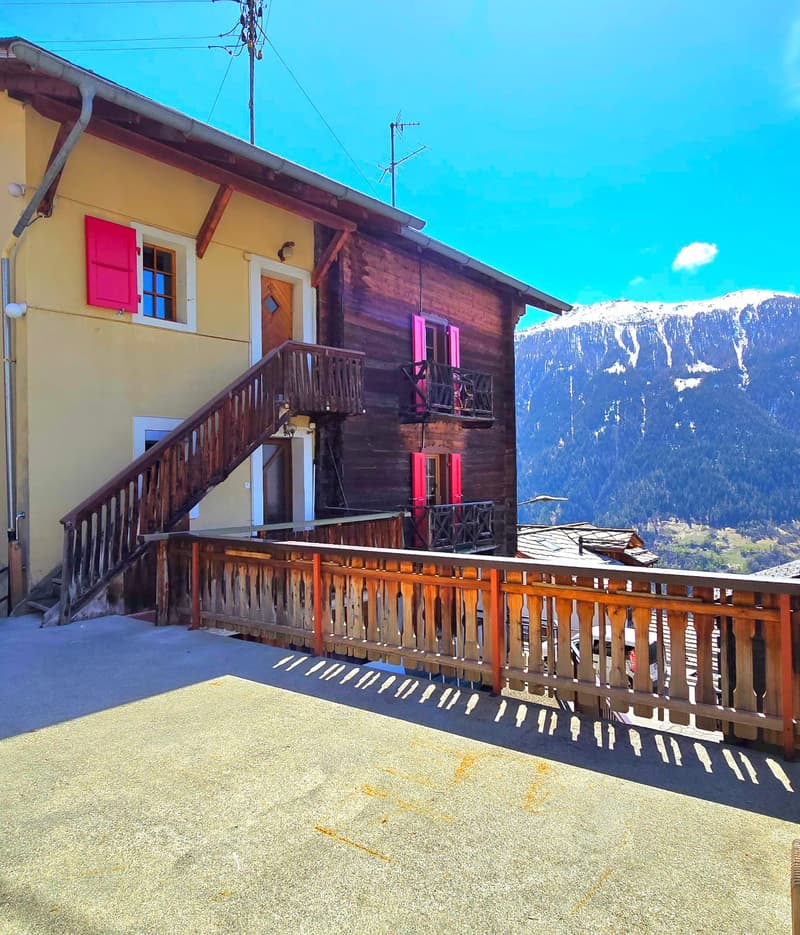 2 story house, wooden exterior, red shutters, wooden balcony, stairs, mountain view
