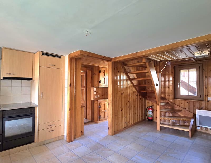 kitchen with wooden cabinets, tiled floor, gas stove, oven, fire extinguisher, wooden staircase