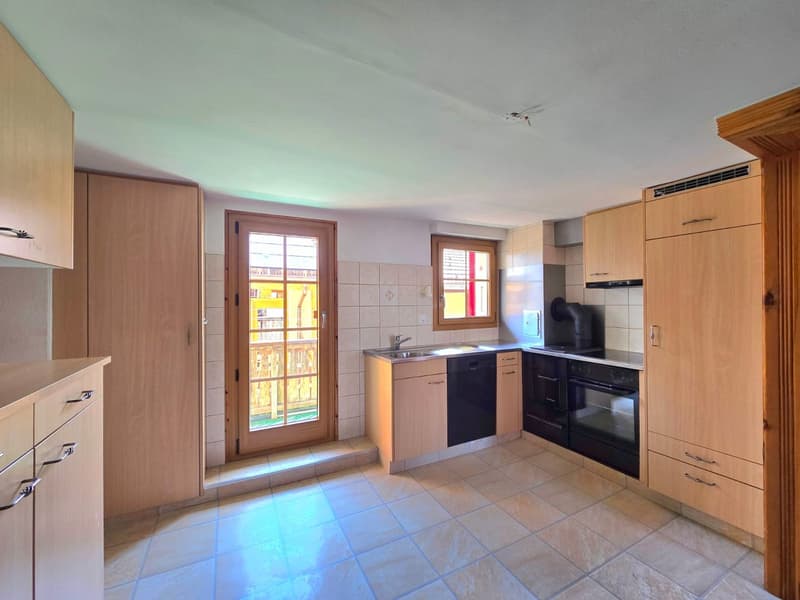 modern kitchen with wooden cabinets, tiled floor, sink, oven, dishwasher, window with balcony