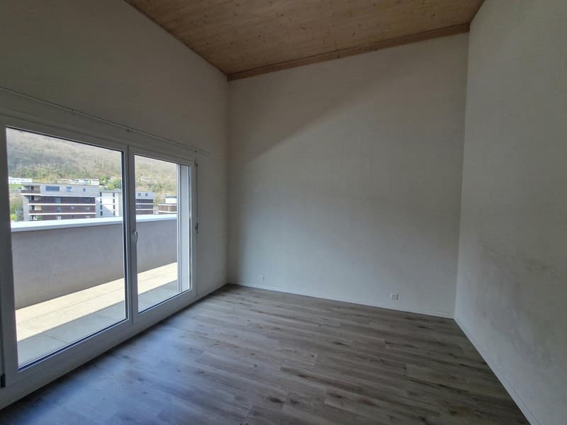 Spacious bedroom with large windows, hardwood flooring, and access to a balcony or terrace.