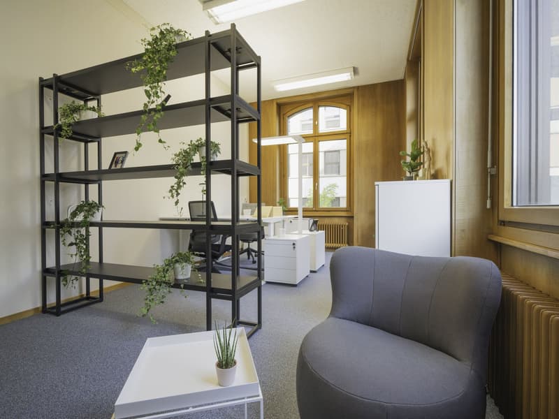 contemporary office, high ceilings, large windows, black metal shelving, gray bean bag chair, radiators, desk, computer
