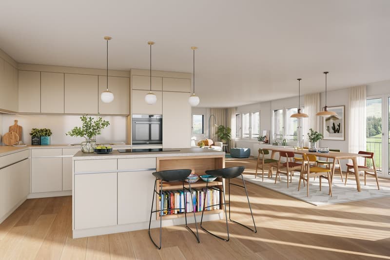 Spacious open-plan kitchen and dining area with modern, light-colored cabinetry, stainless steel appliances including a dishwasher, wooden countertops, and a large dining table with chairs. The room features large windows overlooking a scenic outdoor view