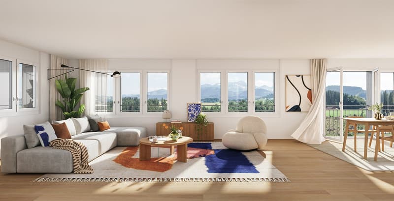Spacious living room with large windows offering a scenic mountain view, grey sectional sofa, round wooden coffee table, patterned area rug, potted plant, and artwork on the wall