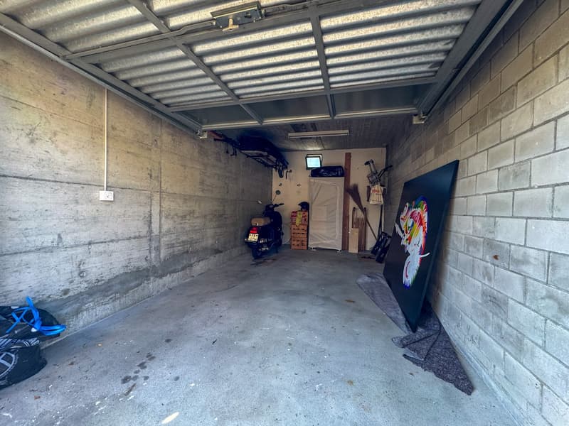 concrete walls, motorcycle, storage items, artwork on floor