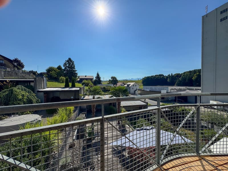 balcony with railings, view of greenery and houses in the distance, clear blue sky