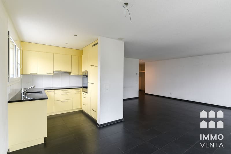 / a picture of an empty room with a black floor and a white kitchen
