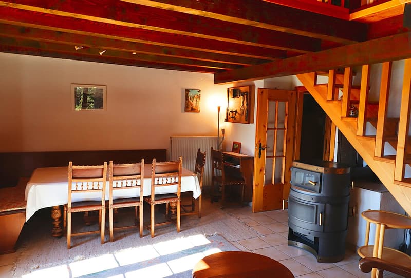 dining room with wooden table and chairs, radiator, wooden stairs, fireplace