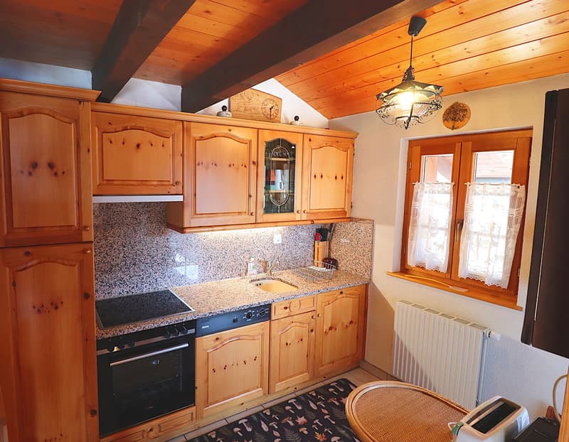 kitchen with wooden cabinets, granite countertop, gas stove, sink, dishwasher, oven, wooden floor, ceiling beams, window with view