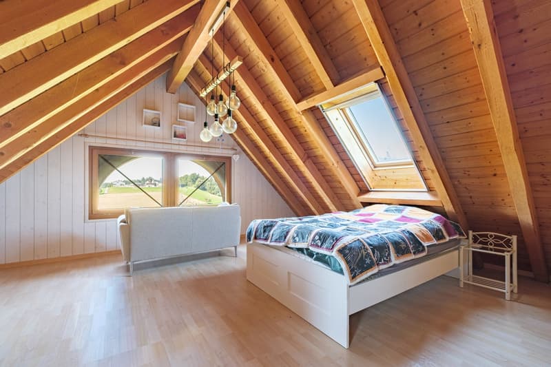 attic bedroom with wooden ceiling, wooden floor, window, bed, couch, white wall,  light