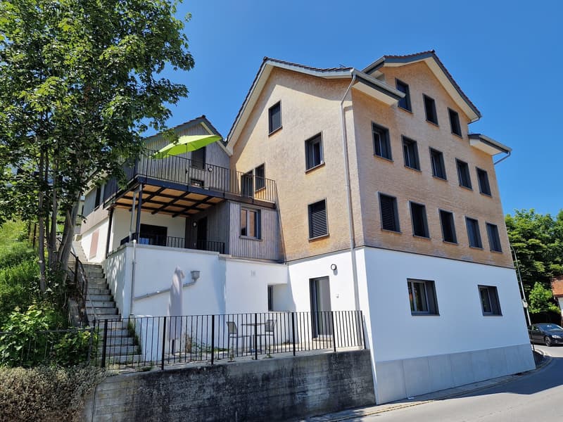 3 story house, brown brick, white windows, balcony, stairs, car parked
