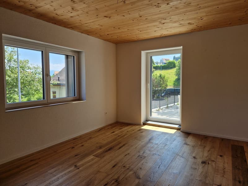 empty room, wooden floor, two windows, sliding door to balcony, power outlet