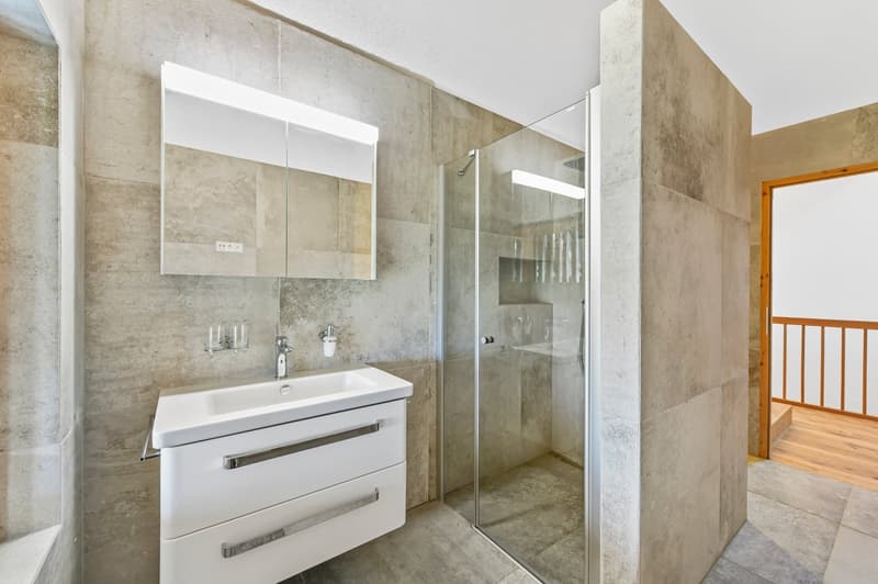 modern bathroom with white sink, mirror, shower, and wooden floor