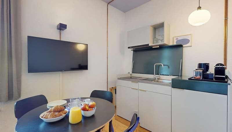 modern small kitchen, dining table, table with croissants, coffee, orange juice, sink, television