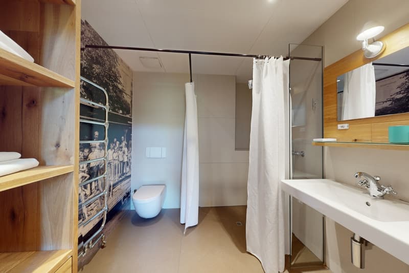 white tiled floor, glass shower, white sink, white toilet, white towels, wooden shelf, white shower curtain