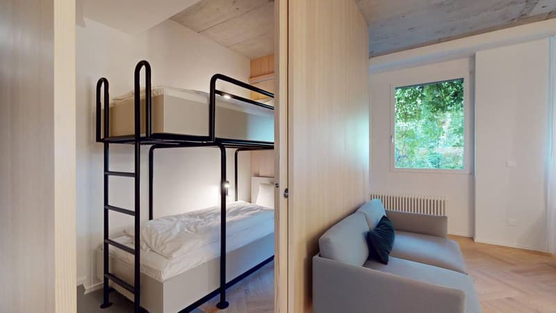 double bunk bed, couch, white walls, window with view to the outside