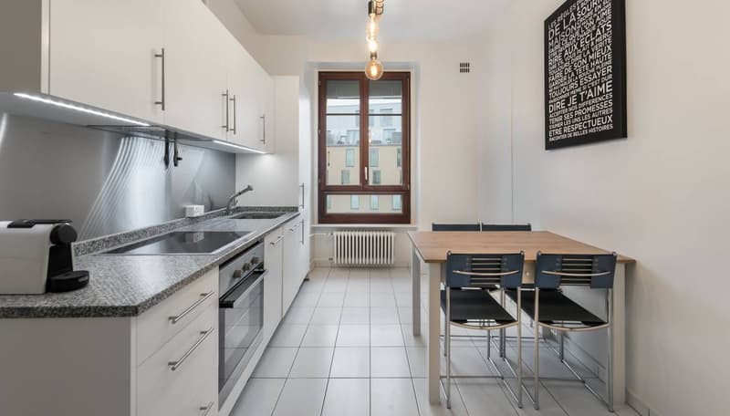 modern kitchen, stainless steel appliances, granite countertop, white cabinets, dining table, window with view