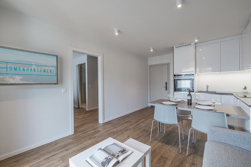 modern open kitchen, dining area, wooden floors, modern lighting, tv on wall