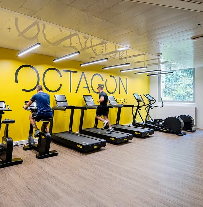 Gym area, treadmills, elliptical trainers, workout space, yellow wall, 10 exercise machines