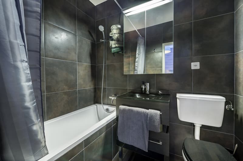 Bathroom with bathtub, sink, toilet, and mirror