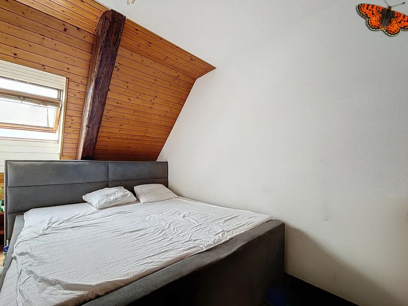 / a small bedroom with wooden walls and a white mattress on the bed