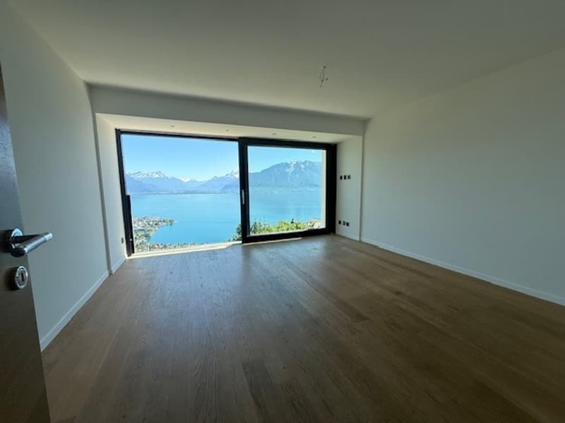empty room, wooden floor, large windows, white walls, view of lake and mountains