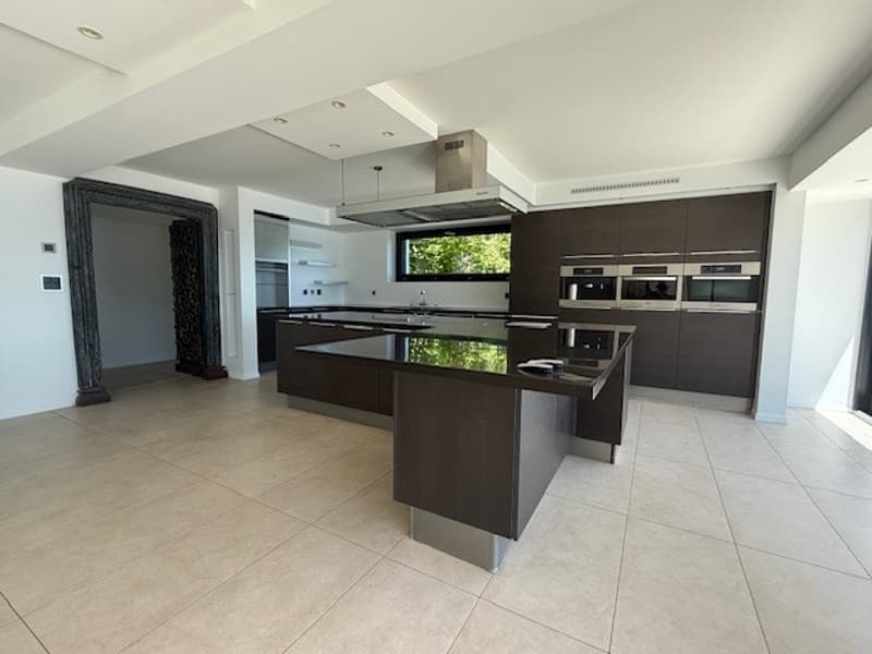 modern kitchen, island, black countertops, stainless steel appliances, white walls, tiled floor