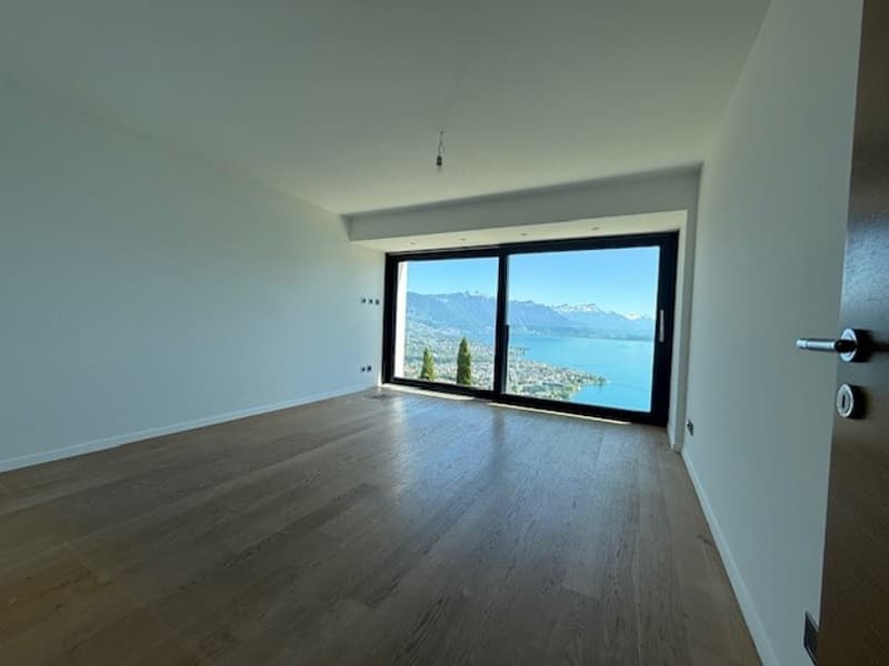 empty room, wooden floor, white walls, large windows, view of mountains and lake