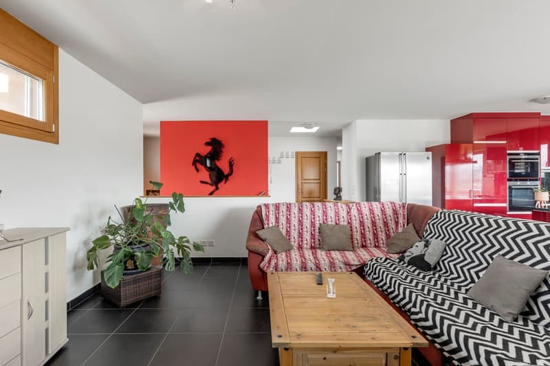 red wall with Ferrari horse, wooden sofa, white wooden table, red and white sofa, red kitchen cabinet, potted plant
