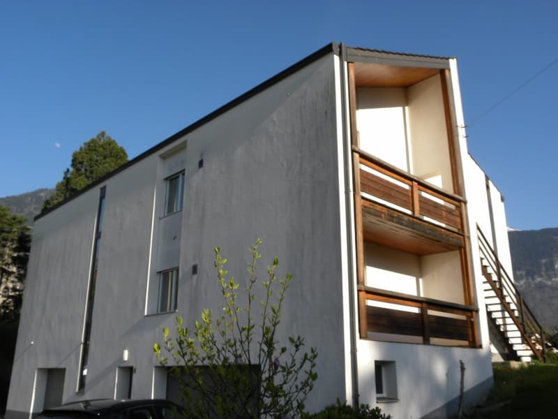 modern white building, 3 floors, wooden balconies, windows, car parked in front