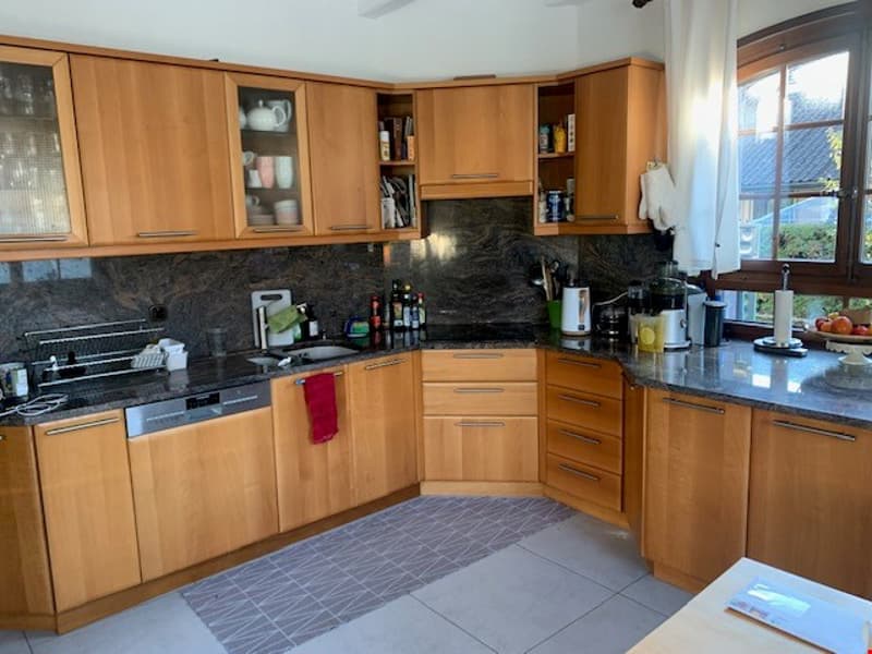 L-shaped kitchen with wooden cabinets, black granite countertops, tile flooring, and a dishwasher visible.