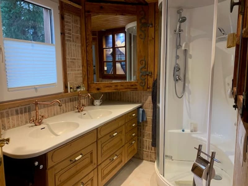 double sink, wooden cabinets, shower enclosure, shower head, faucets