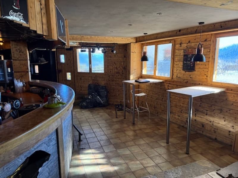 bar area, two tables, bar counter, windows, wooden walls, tiled floor, ceiling lamps