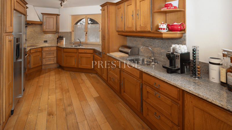 granite countertops, wooden cabinets, built-in oven, kitchen island, coffee machine, sink, refrigerator, wine rack, coffee pods