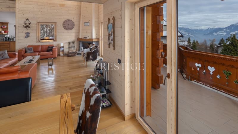 wooden floor, fireplace, large windows, balcony, sofa, coffee table, cowhide chair, wooden table, view of mountains
