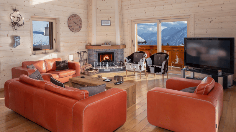 Living room with wooden walls, fireplace, sofa, coffee table, and mountain view