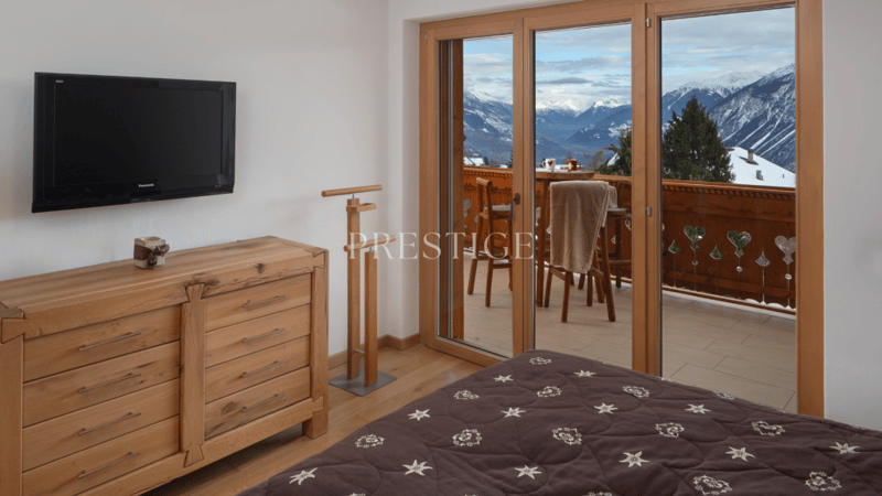 large bed, wooden dresser, balcony, tv, balcony table, view