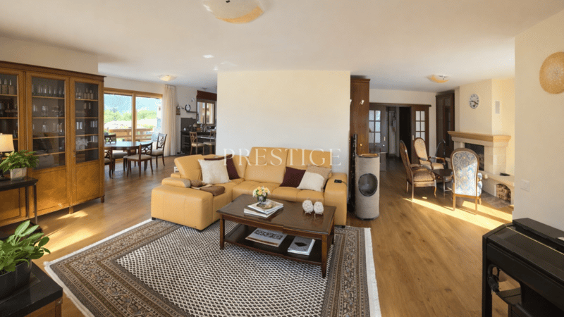 Wooden floors, Fireplace, leather couch, coffee table, rug, wooden cabinet, dining table and chairs, view of mountains