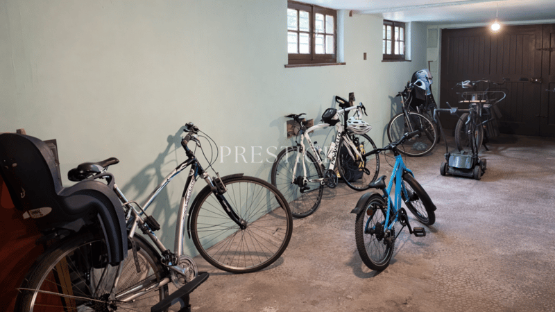 concrete floor, 6 bicycles, 1 exercise bike, 3 helmets, 2 windows
