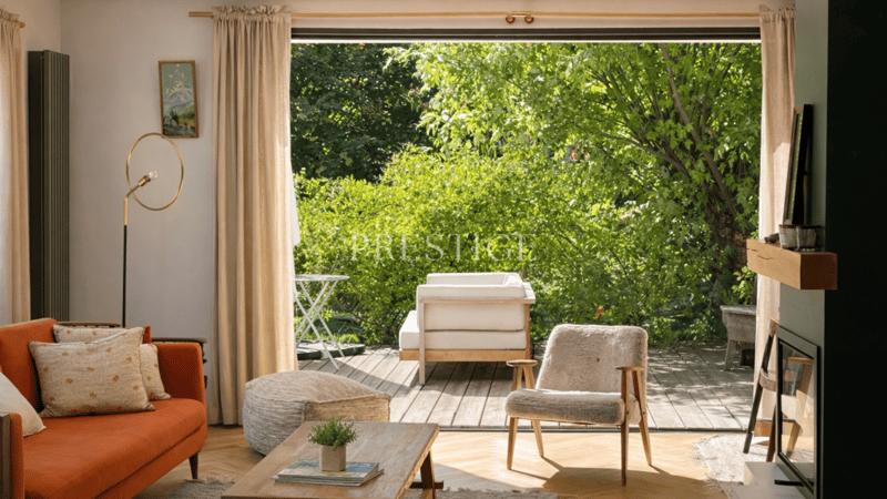 large windows, balcony, hardwood floors, couch, wooden table, side table, armchair, standing lamp, fireplace